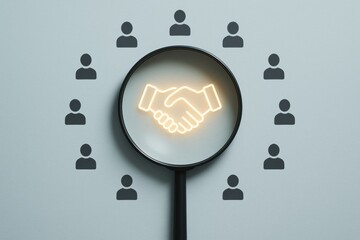 Fototapeta premium Business Partnership Focus: A magnifying glass highlights a handshake icon surrounded by small person figures, symbolizing collaboration and unity.