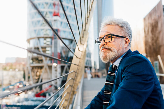 Contemplative senior businessman standing outside on sunny day