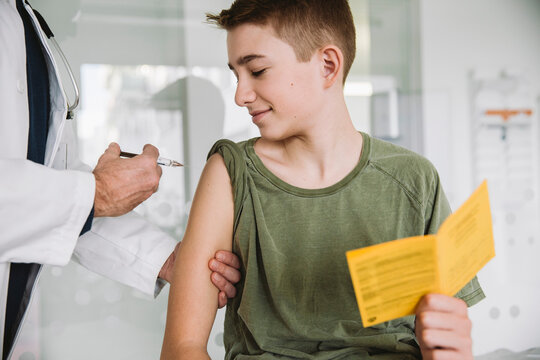 Doctor injecting a vaccine into teenager?s arm