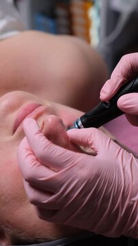A woman undergoing a rejuvenating facial treatment in a beauty clinic. Beauty technology in use. Close-up