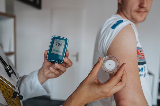 Doctor measuring blood glucose of patient in clinic