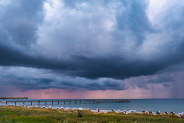 Dark rain clouds over Boltenhagen Beach on the Baltic Sea in Mecklenburg-Western Pomerania at sunset