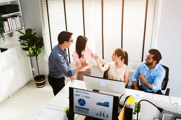Diverse business team celebrating a win in a bright modern office. Group shows excitement with raised fists and smiles, symbolizing motivation, success, and strong collaboration.