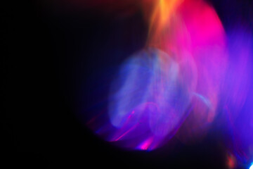 Abstract blurred colorful lens flare bokeh on black,