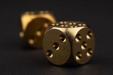 Two golden dice on black background