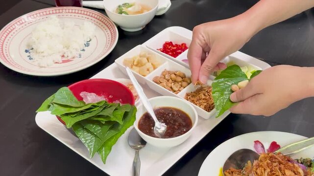 Assembling Miang Kham Savory Leaf Wraps at Dining Table