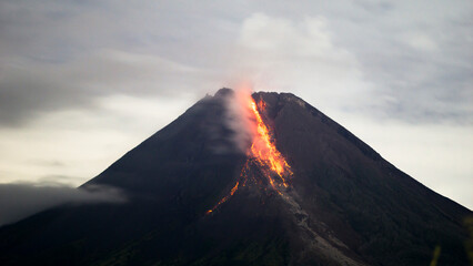 Mount Merapi Erupting with Glowing Lava Flow at Night © fadholi