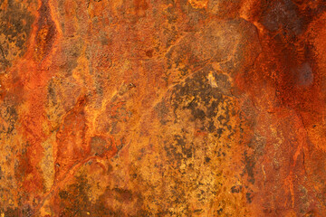 Texture of heavily rusted iron sheet showing layers of decay and oxidation ideal for use in...