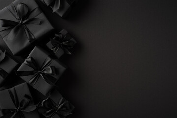 Dark gift boxes with black satin ribbons artfully arranged on a moody, minimalistic backdrop...