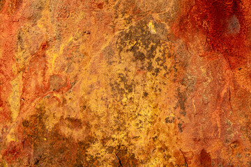 Texture of heavily rusted iron sheet showing layers of decay and oxidation ideal for use in...