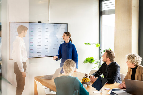 Young businesswoman having discussion with colleagues in meeting
