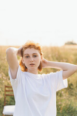 Sunlit Portrait of Young Redhead Woman in White T-Shirt