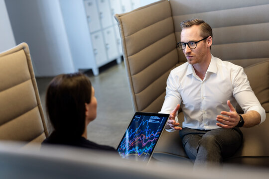 Business people having discussion over tablet PC in office