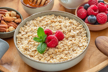 Bowl of porridge or oatmeal with fruits close up. Breakfast concept.
