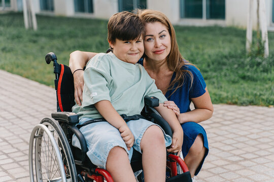 Portrait of a mother and son with sma desease in a wheelchair - Powered by Adobe