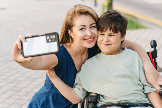 Close up a mother taking selfie with her teenager son in a wheelchair, lifestyle concept