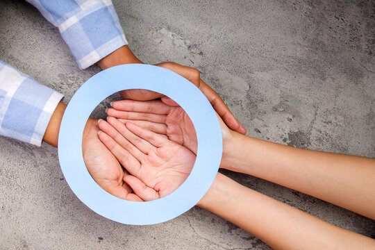 Hands Holding Diabetes Blue Ring Symbol On Grey Texture Background