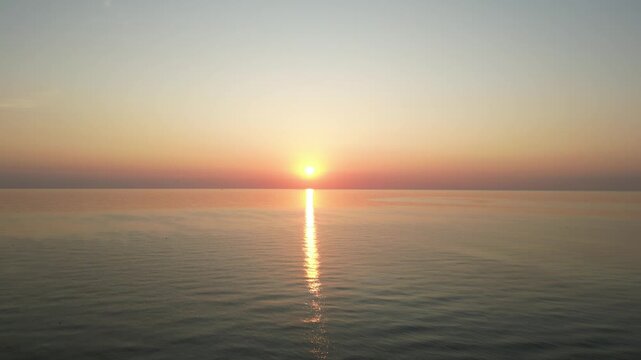 Serene Sunset Over the Sea: The sun dips below the horizon, casting a warm glow across the tranquil expanse of the sea, creating a moment of peace and reflection. Rimini, Emilia-Romagna