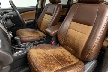 Worn brown leather car seats, interior view