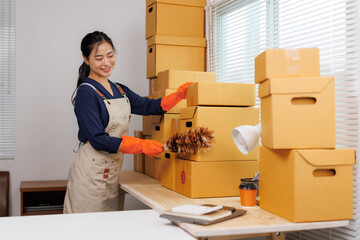 Asian female seller cleaning stock keeping unit boxes in warehouse