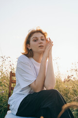 Woman Posing Gracefully in Sunlit Field at Golden Hour
