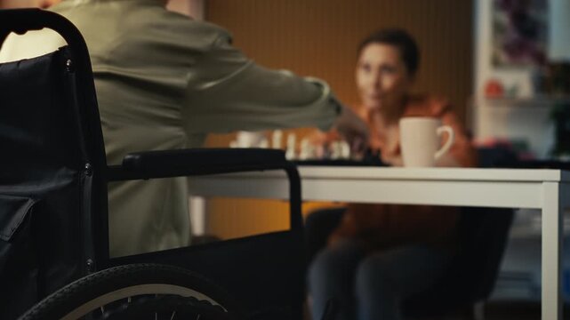 Woman with reduced mobility playing chess with best female friend, relaxing game