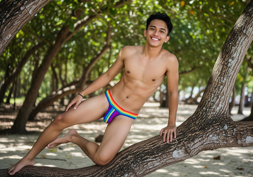 Happy young southeast asia man in colorful swim briefs sitting on a tropical tree at the beach. Ideal image for summer holidays, beach travel, relaxation, freedom, and vibrant outdoor lifestyle themes