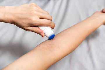 Apply itchy liquid to mosquito bites with one hand