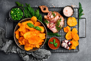Potato chips with bacon in a ceramic bowl. Salty snacks for beer.
