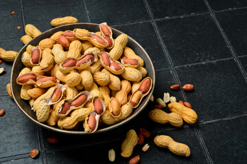 Nuts. Roasted peanuts in a ceramic bowl. Close-up. Free space for text.