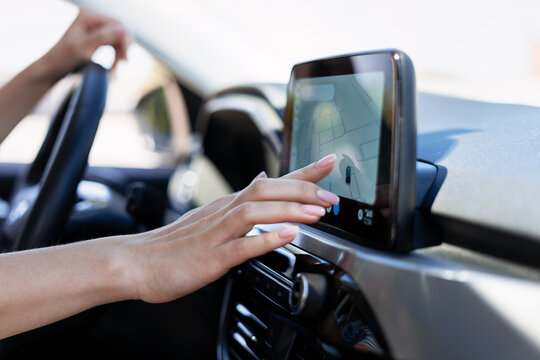 Woman driving car using navigation system on dashboard touchscreen