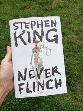 Hand Holding Stephen King's Never Flinch Novel