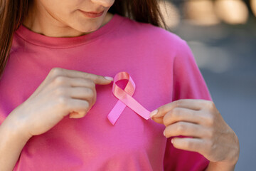 Woman showing pink ribbon supporting breast cancer awareness