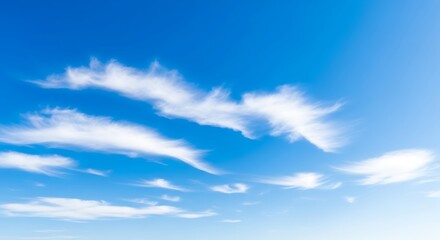 Bright blue sky with soft white cirrus clouds on a clear sunny day, peaceful and tranquil atmosphere