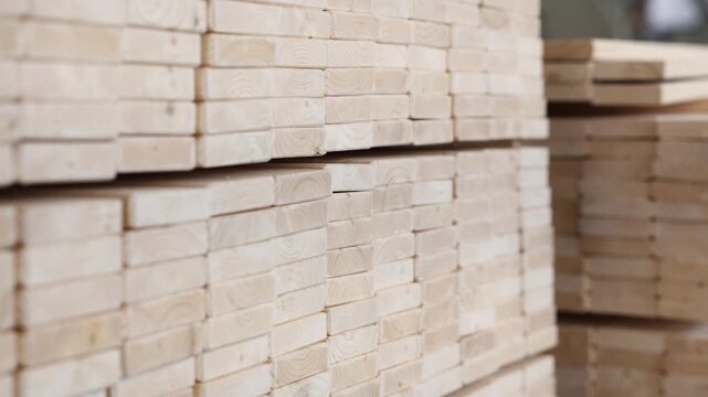 Rows of neatly stacked pine timber planks in a workshop or warehouse, showing clean edges, uniform size, and natural grain ready for woodworking or construction use