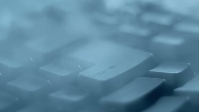 A man's finger hits the Enter key with force and the smoke that covered the keyboard spreads out in a circular wave in different directions. Closeup. Macro. Slow mo, slow motion, high speed camera - Powered by Adobe
