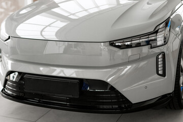Fototapeta premium Modern electric car reflecting showroom lights in dealership