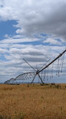 An Irrigation System Over Crop Fields, Set Beneath a Beautiful, Cloudy Sky Above