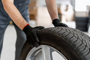 Mechanic inspecting car tire in auto repair shop
