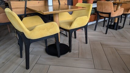 The Stylish Cafe has Modern Yellow Chairs and Wooden Tables for an inviting vibe