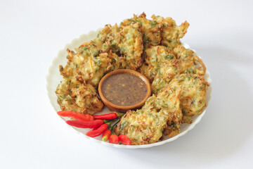 Bakwan or Vegetable fritters with peanut sauce and red chili. Vegetable fritters are fried snacks made from a mixture of vegetables and flour batter, usually fried until crispy. Bala Bala or Ote Ote.