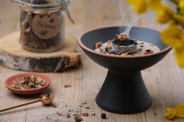 Top view of Beltane incense ritual with frankincense, resins, and dried herbs
