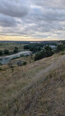 A Beautiful Scenic River Bend at Sunset Amidst Rolling Hills and Idyllic Countryside