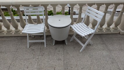 Attractive Outdoor Patio Seating that Features Charming White Chairs and a Table Setup