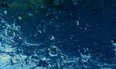Clean blue water splash in motion with many bubbles and drops background