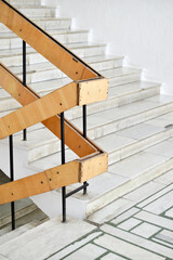 A flight of stairs with marble steps. Whitewashed walls and wooden staircase railings. The...