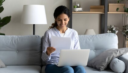 _Young indian woman holding letter using laptop computer application paying bill onlin .