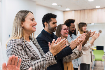 Happy business people clapping hands after a presentation in office