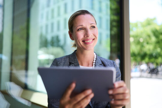 Smiling businesswoman holding tablet PC
