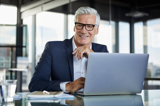 Businessman working in office, using laptop